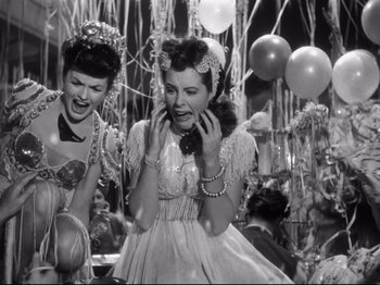 Movie still from “Gilda” (1946), directed by Charles Vidor – Two women are talking on the phone at a party; Medium shot, Low angle