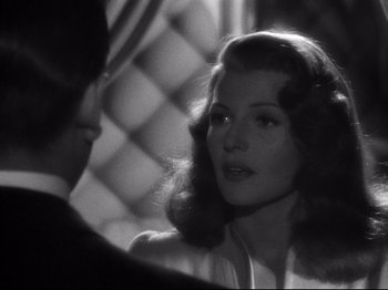 Movie still from “Gilda” (1946), directed by Charles Vidor – A black - and - white photo of a man and a woman; Close Up shot, Over the shoulder angle