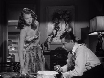 Movie still from “Gilda” (1946), directed by Charles Vidor – A man and a woman standing next to each other in a room; Medium shot, Low angle