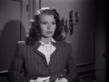 Movie still from “Gilda” (1946), directed by Charles Vidor – A black and white photo of a woman in a suit; Medium shot, Low angle