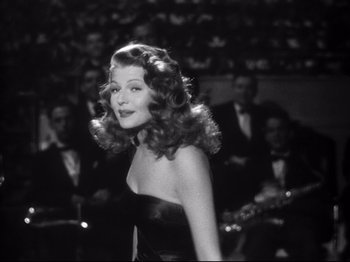 Movie still from “Gilda” (1946), directed by Charles Vidor – A black and white photo of a woman in a black dress; Medium shot, Over the shoulder angle