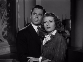 Movie still from “Gilda” (1946), directed by Charles Vidor – A man and a woman standing next to each other; Medium shot, Low angle