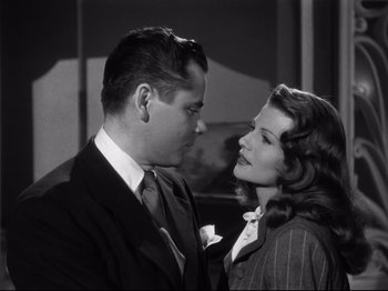 Movie still from “Gilda” (1946), directed by Charles Vidor – A man and a woman standing next to each other; Medium shot, Low angle