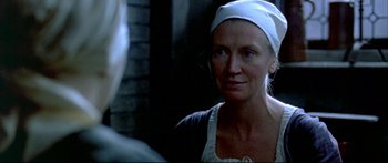 Movie still from “Girl with a Pearl Earring” (2003), directed by Peter Webber – A woman wearing a white head covering looking into a mirror; Close Up shot, Over the shoulder angle