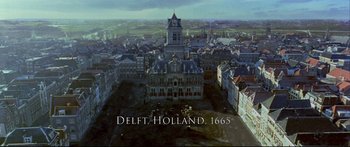 Movie still from “Girl with a Pearl Earring” (2003), directed by Peter Webber – An aerial view of a town with a church in the center; Extreme Wide shot, High angle
