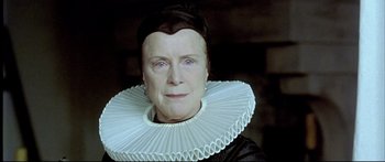 Movie still from “Girl with a Pearl Earring” (2003), directed by Peter Webber – An older woman wearing a large white collar; Close Up shot, Low angle