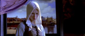Movie still from “Girl with a Pearl Earring” (2003), directed by Peter Webber – A young woman wearing a white head covering; Close Up shot, Low angle