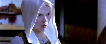Movie still from “Girl with a Pearl Earring” (2003), directed by Peter Webber – A young woman wearing a head scarf and a white dress; Close Up shot, Low angle