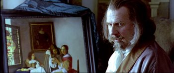Movie still from “Girl with a Pearl Earring” (2003), directed by Peter Webber – A man standing in front of a painting of a family; Close Up shot, Over the shoulder angle