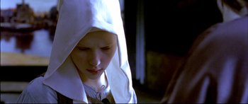 Movie still from “Girl with a Pearl Earring” (2003), directed by Peter Webber – A young girl wearing a white robe and a white hat; Close Up shot, Low angle