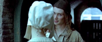 Movie still from “Girl with a Pearl Earring” (2003), directed by Peter Webber – A man in a hat is looking at a woman in a hat; Close Up shot, Over the shoulder angle