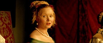 Movie still from “Girl with a Pearl Earring” (2003), directed by Peter Webber – A young woman wearing pearls and a green dress; Close Up shot, Over the shoulder angle