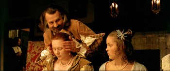 Movie still from “Girl with a Pearl Earring” (2003), directed by Peter Webber – Two women and an old man are getting their hair done; Close Up shot, Over the shoulder angle