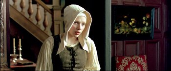 Movie still from “Girl with a Pearl Earring” (2003), directed by Peter Webber – A young woman in a medieval dress with a white hood; Close Up shot, Over the shoulder angle