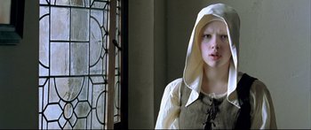 Movie still from “Girl with a Pearl Earring” (2003), directed by Peter Webber – A young girl in medieval garb stands in front of a window; Close Up shot, Low angle
