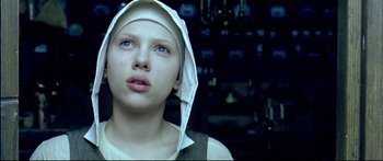 Movie still from “Girl with a Pearl Earring” (2003), directed by Peter Webber – A young girl wearing a white hood looking up; Close Up shot, Overhead angle