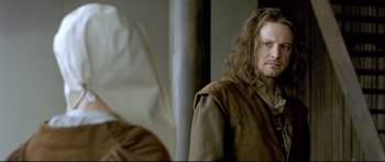 Movie still from “Girl with a Pearl Earring” (2003), directed by Peter Webber – A man with long hair is standing next to another man; Close Up shot, Over the shoulder angle
