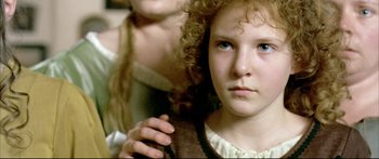 Movie still from “Girl with a Pearl Earring” (2003), directed by Peter Webber – A young girl with curly red hair holding a tie; Close Up shot, High angle