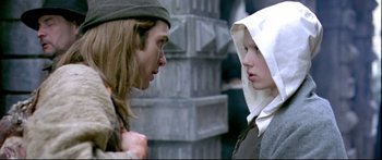 Movie still from “Girl with a Pearl Earring” (2003), directed by Peter Webber – A man and a woman face each other in front of a brick wall; Medium shot, Over the shoulder angle