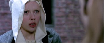 Movie still from “Girl with a Pearl Earring” (2003), directed by Peter Webber – A young woman with a head scarf on her head; Close Up shot, Over the shoulder angle
