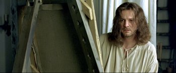 Movie still from “Girl with a Pearl Earring” (2003), directed by Peter Webber – A man standing next to a ladder in a room; Medium shot, Low angle