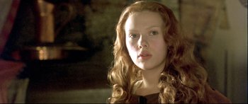 Movie still from “Girl with a Pearl Earring” (2003), directed by Peter Webber – A woman with long red hair is looking at the camera; Close Up shot, Low angle