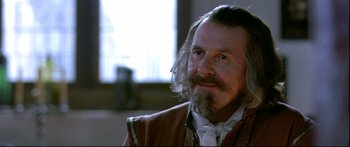 Movie still from “Girl with a Pearl Earring” (2003), directed by Peter Webber – An older man with long hair and a beard; Close Up shot, Over the shoulder angle