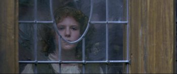 Movie still from “Girl with a Pearl Earring” (2003), directed by Peter Webber – A young girl looking out a window through a cage; Close Up shot, High angle