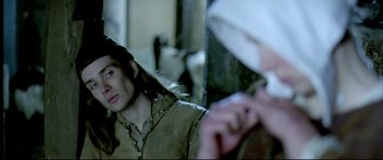 Movie still from “Girl with a Pearl Earring” (2003), directed by Peter Webber – A woman in a brown jacket and a man in a white hat; Close Up shot, Over the shoulder angle