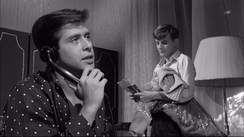 Movie still from “Girl with a Suitcase” (1961), directed by Valerio Zurlini – A young man holding a phone and a young man reading a book; Close Up shot, Low angle