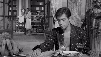 Movie still from “Girl with a Suitcase” (1961), directed by Valerio Zurlini – A man sitting at a table with a glass of wine; Medium shot, High angle