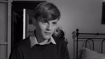 Movie still from “Girl with a Suitcase” (1961), directed by Valerio Zurlini – A young man in a black shirt and white shirt; Close Up shot, High angle