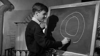 Movie still from “Girl with a Suitcase” (1961), directed by Valerio Zurlini – A young boy is writing on a chalkboard; Close Up shot, High angle