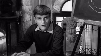 Movie still from “Girl with a Suitcase” (1961), directed by Valerio Zurlini – A young man sitting in front of a statue; Close Up shot, High angle