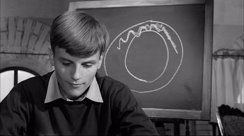 Movie still from “Girl with a Suitcase” (1961), directed by Valerio Zurlini – A young man sitting in front of a chalkboard; Close Up shot, High angle