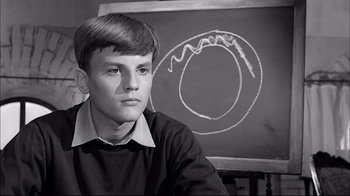 Movie still from “Girl with a Suitcase” (1961), directed by Valerio Zurlini – A young man sitting in front of a chalkboard; Close Up shot, High angle