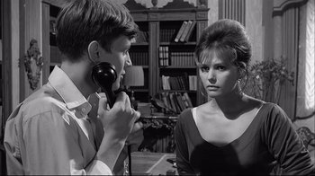 Movie still from “Girl with a Suitcase” (1961), directed by Valerio Zurlini – A man and a woman talking to each other in front of a bookcase; Close Up shot, Over the shoulder angle