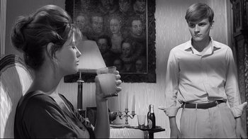 Movie still from “Girl with a Suitcase” (1961), directed by Valerio Zurlini – A woman holding a cup in front of a young man; Medium shot, Over the shoulder angle