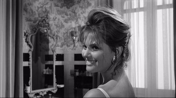 Movie still from “Girl with a Suitcase” (1961), directed by Valerio Zurlini – A black and white photo of a woman smiling; Close Up shot, Over the shoulder angle