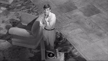 Movie still from “Girl with a Suitcase” (1961), directed by Valerio Zurlini – A man standing in front of a record player; Medium shot, High angle