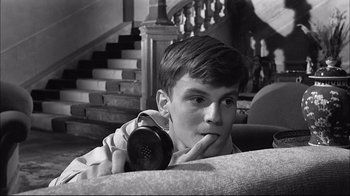 Movie still from “Girl with a Suitcase” (1961), directed by Valerio Zurlini – A young man holding a phone up to his face; Close Up shot, High angle