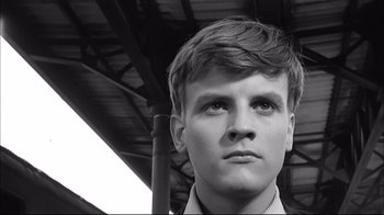 Movie still from “Girl with a Suitcase” (1961), directed by Valerio Zurlini – A young man is looking into the distance; Close Up shot, Low angle
