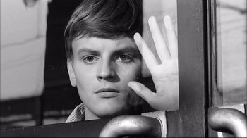 Movie still from “Girl with a Suitcase” (1961), directed by Valerio Zurlini – A young man holding his hand up to his face in front of a mirror; Close Up shot, High angle