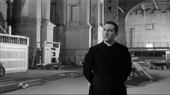 Movie still from “Girl with a Suitcase” (1961), directed by Valerio Zurlini – A man standing in front of an old building; Medium shot, Low angle