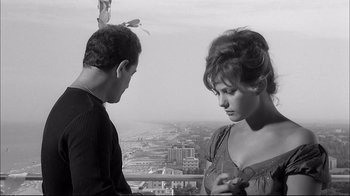 Movie still from “Girl with a Suitcase” (1961), directed by Valerio Zurlini – A man and a woman standing next to each other on a balcony; Medium shot, High angle