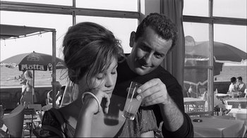 Movie still from “Girl with a Suitcase” (1961), directed by Valerio Zurlini – A man and a woman holding a glass of water; Medium shot, Low angle