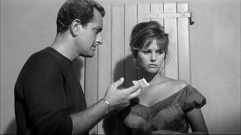 Movie still from “Girl with a Suitcase” (1961), directed by Valerio Zurlini – A man holding a piece of paper in front of a woman's face; Medium shot, Over the shoulder angle