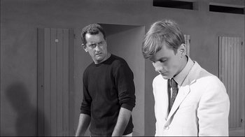 Movie still from “Girl with a Suitcase” (1961), directed by Valerio Zurlini – A man standing next to another man in a suit; Medium shot, Over the shoulder angle