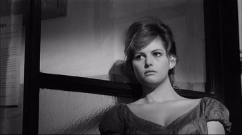 Movie still from “Girl with a Suitcase” (1961), directed by Valerio Zurlini – A black - and - white photo of a woman in front of a window; Close Up shot, Low angle