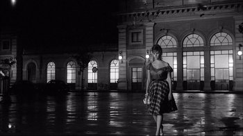 Movie still from “Girl with a Suitcase” (1961), directed by Valerio Zurlini – A black and white photo of a woman in a dress; Wide shot, Low angle